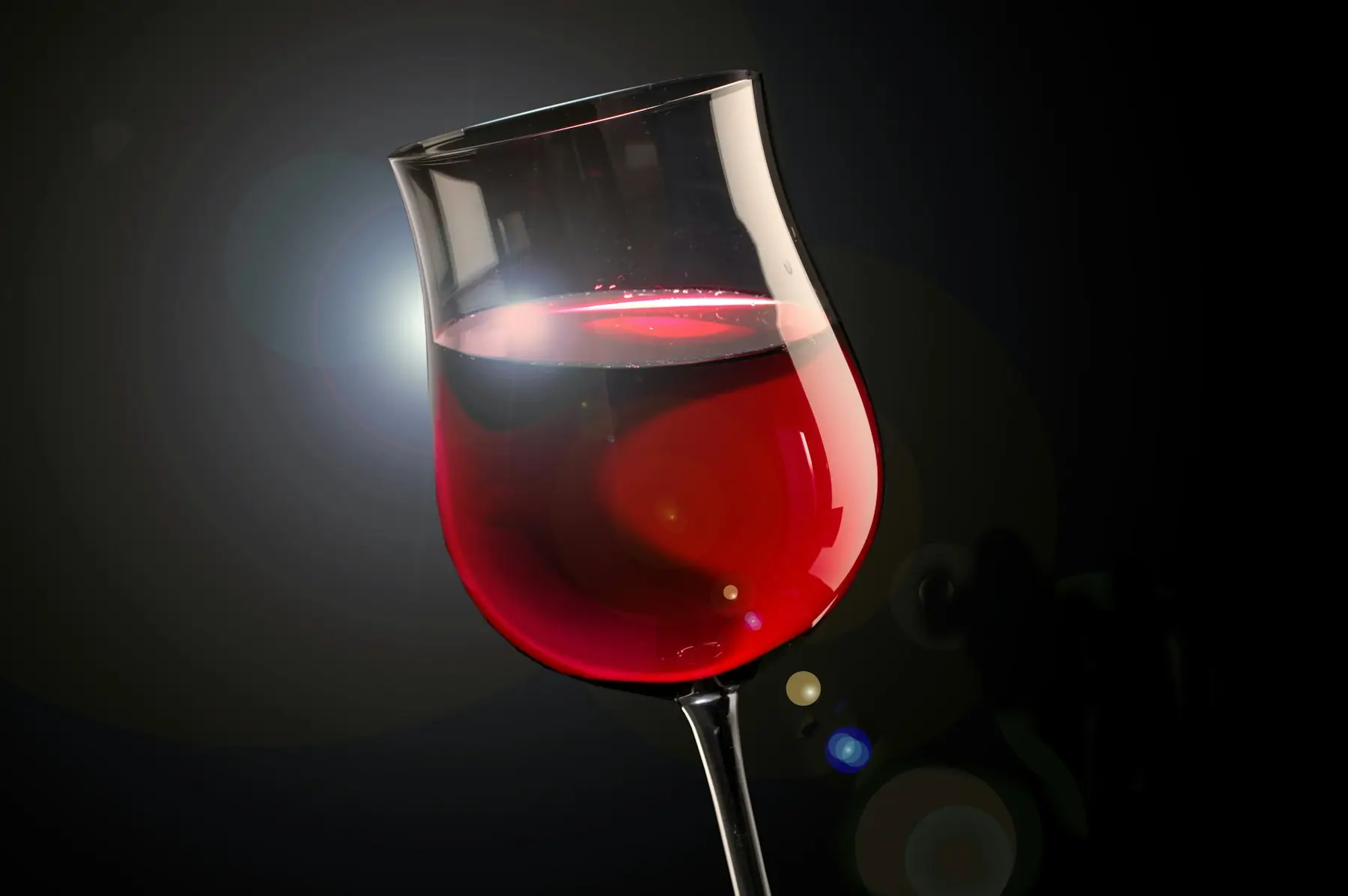 A glass of red wine against a dark background