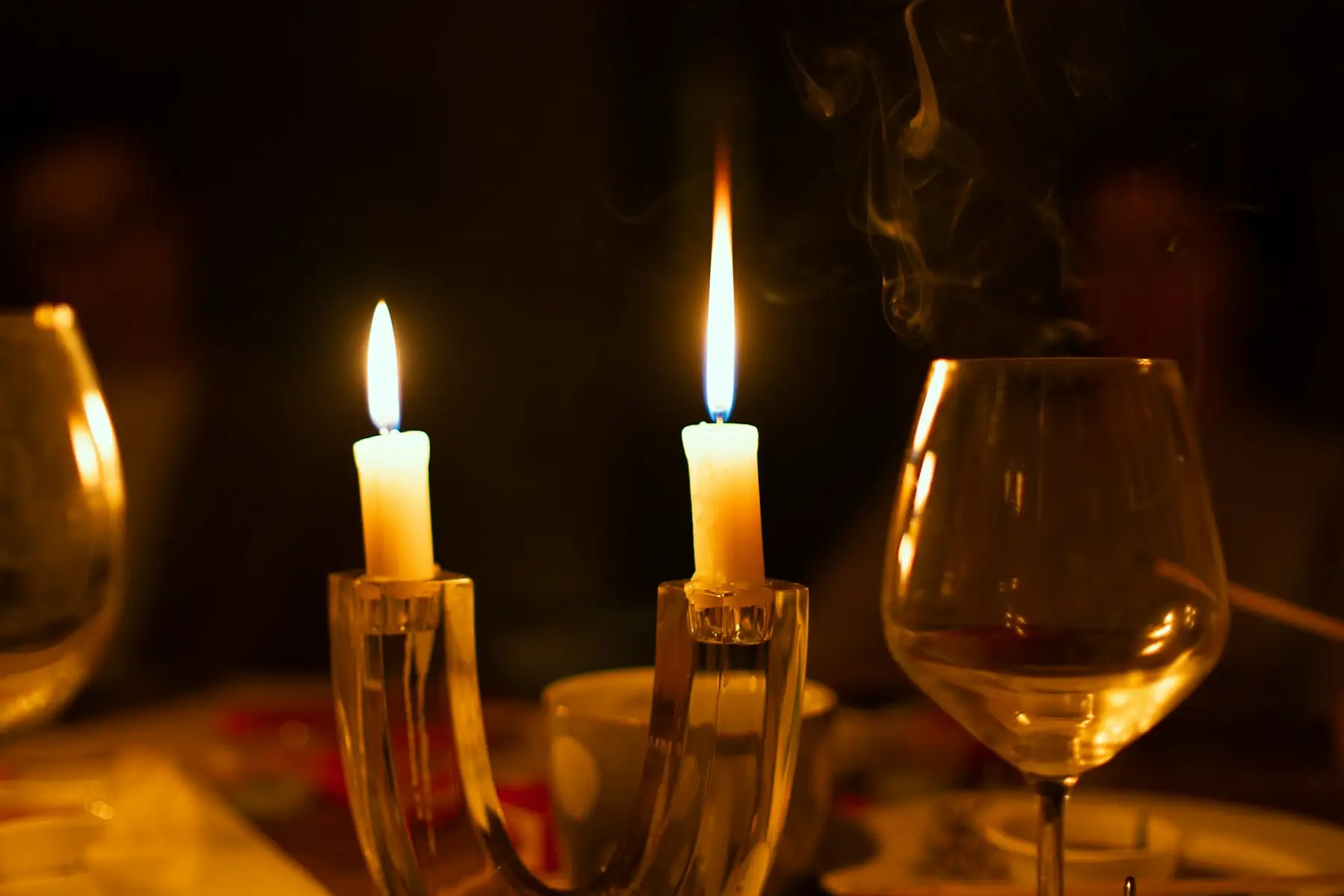 Candles and a wine glass on a table at night